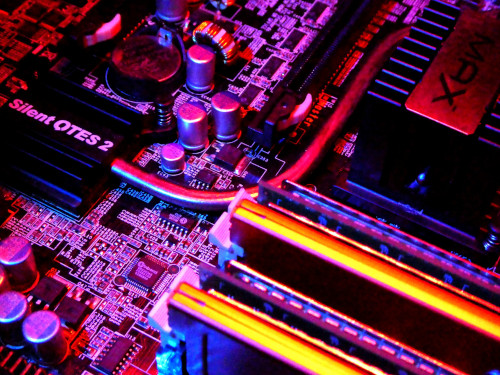 A close-up of a PC motherboard with colourful lighting